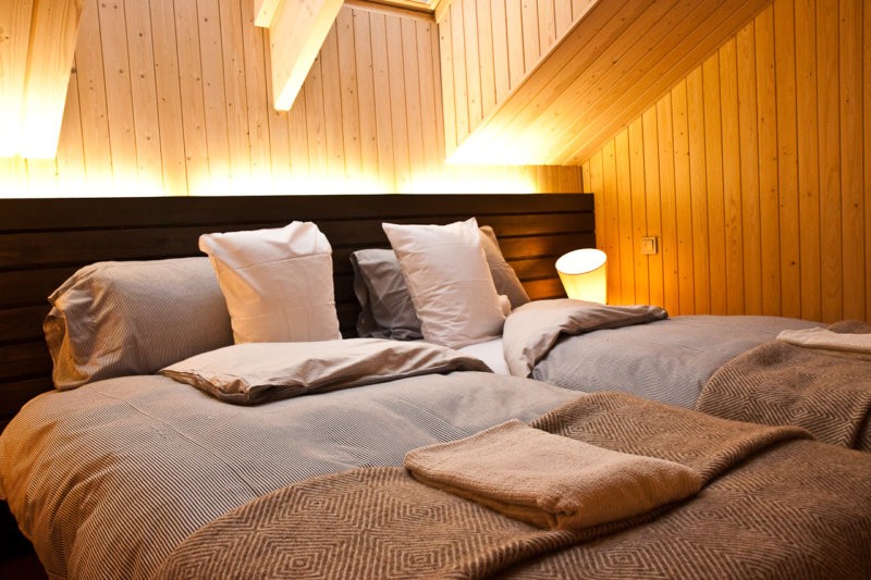 Подсветка изголовья кровати в спальне с деревянной отделкой