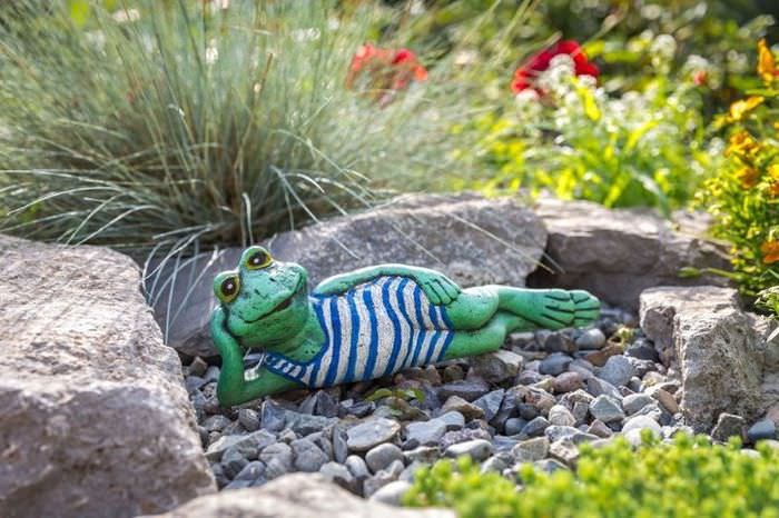 Фигурка лягушонка из мультфильма в декоре сада