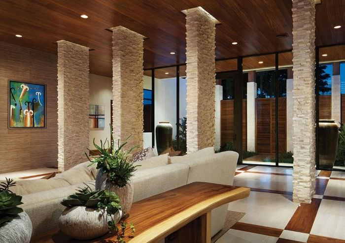 Зонирование пространства гостиной с помощью колонн из натурального камня